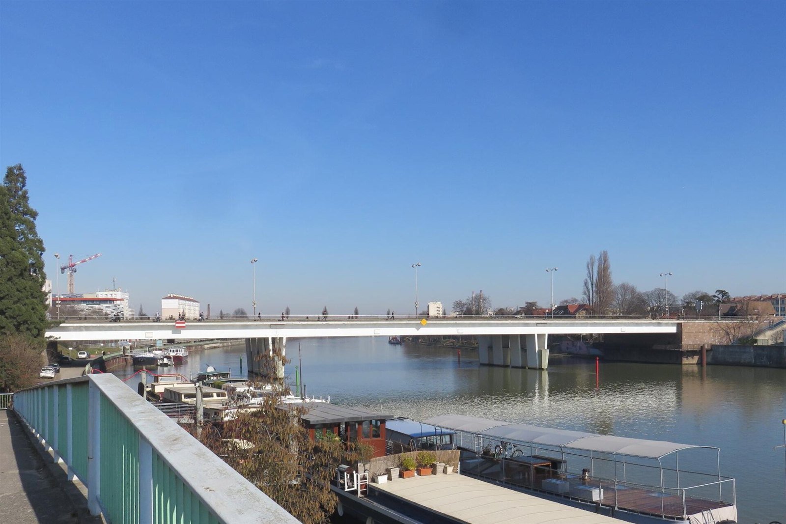 Le pont de Choisy au-dessus de la Seine, avec des péniches amarrées, à Choisy-le-Roi